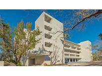 Modern condo building with manicured landscaping, garage parking, and beach access at 250 Sands Point Rd # 5101, Longboat Key, FL 34228