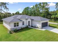 Beautiful single Gathering home showcasing modern design, neutral colors, a well-manicured lawn, and a two-car garage at 3294 Gowanda Ave, North Port, FL 34287