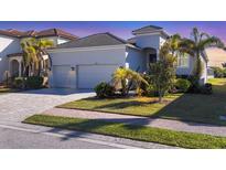 Beautiful two-story home features a paver driveway, two-car garage and tropical landscaping at 6223 Champions Row St, Bradenton, FL 34210