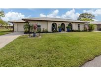 Charming single-story home with a well-manicured lawn and arched entryway at 641 Verrocchio Dr, Nokomis, FL 34275