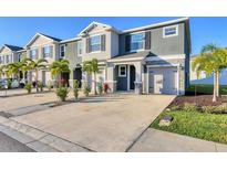 Modern townhome with stone accents, a two-car garage, and tropical landscaping at 6634 Calypso Coral Ln, Sarasota, FL 34240