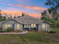 Charming single Gathering home with stone accents and lush landscaping, featuring a covered porch and welcoming entrance at 7415 36Th E Ave, Palmetto, FL 34221