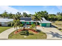 Charming single-story home with a circular driveway, well-maintained landscaping, and solar panels at 198 Salem Nw Ave, Port Charlotte, FL 33952