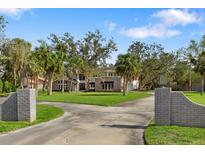 Stately two-story home boasts a brick facade, a sprawling lawn and mature landscaping at 3783 Beneva Oaks Blvd, Sarasota, FL 34238
