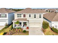 Inviting two-story home featuring a manicured front yard and a cozy front porch at 5117 Sultana Cv, Bradenton, FL 34211