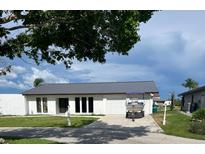 Single-story home with a well-maintained lawn, gray roof, and a boat parked on the driveway at 5174 Conner Ter, Port Charlotte, FL 33981
