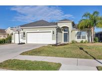 Charming single-story home with a well-manicured lawn, two car garage and a basketball hoop on a sunny day at 12046 Forest Park Cir, Bradenton, FL 34211