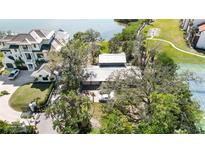 An aerial view of a beautiful waterfront home with lush landscaping, a tennis court, and mature trees at 1621 Memory Ln, Sarasota, FL 34231