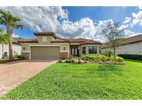 Charming single-story home with a well-manicured lawn, beautiful landscaping, and a tile roof at 16218 Umbria Pl, Bradenton, FL 34211