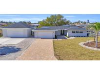 Charming single-story home boasting a paver driveway, separate garage, and freshly landscaped yard at 1950 Fairview Dr, Englewood, FL 34223