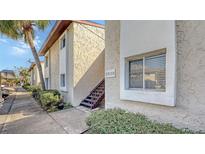 Exterior shot of a two-story condo building featuring stucco walls, stairs, and manicured landscaping at 2620 Hidden Lake N Dr # B, Sarasota, FL 34237