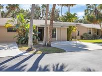 Charming single-story home with a carport, mature trees, and tropical landscaping at 5060 Village Gardens Dr # 134, Sarasota, FL 34234