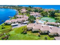 Aerial view of waterfront community showcasing lush landscaping, pool, tennis courts and boat docks at 4234 Gulf Of Mexico Dr # E2, Longboat Key, FL 34228