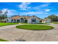 Beautiful single-story home featuring a circular driveway and a separate garage at 5750 Saddle Oak Trl, Sarasota, FL 34241