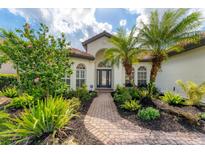 Charming home featuring a tile roof, lush landscaping and a welcoming front entrance with a brick walkway at 6832 Bay Hill Dr, Lakewood Ranch, FL 34202