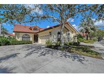 A beautiful single-story home has a well-manicured yard, elegant arched windows, and a two-car garage at 7344 Villa D Este Dr, Sarasota, FL 34238