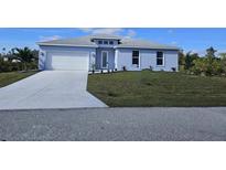 New single-story home with light blue exterior, white garage door, and landscaped lawn at 9245 Zorn St, Port Charlotte, FL 33981