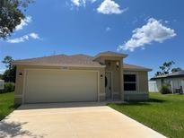 One-story home with a two-car garage and well-manicured lawn at 22235 Albany Ave, Port Charlotte, FL 33952