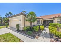 Tan house with garage, walkway, and landscaping at 2539 Thyme Way, North Port, FL 34289