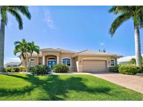 Tan single-Gathering home with palm trees and landscaped yard at 1429 Blue Jay Ct, Punta Gorda, FL 33950
