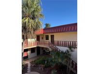 Exterior view of condo building with red roof and lush landscaping at 78 Boundary Blvd # 193, Rotonda West, FL 33947