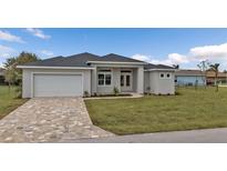 One-story home with gray siding, paved driveway and landscaped lawn at 206 Gold Tree, Punta Gorda, FL 33955