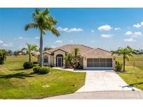 Charming one-story home with a tile roof, large driveway, two-car garage, and meticulously maintained landscaping at 16446 Belo Ct, Punta Gorda, FL 33955