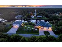 Stunning aerial view of waterfront home at dusk, showcasing expansive property and canal access at 1025 Cheshire St, Port Charlotte, FL 33953