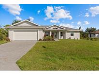 White single-story house with a two-car garage and a spacious lawn at 8136 Welsford Rd, Port Charlotte, FL 33981