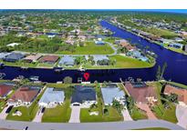 Aerial view of waterfront homes along a canal, showcasing community and waterfront lifestyle at 9310 Rosebud Cir, Port Charlotte, FL 33981
