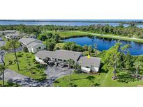 Aerial view of condo community near lake, showcasing building and landscaping at 4260 Placida Rd # 15D, Englewood, FL 34224