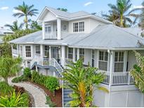 Two story house with gray metal roof, white siding, and lush landscaping at 116 Dolly St, Punta Gorda, FL 33950