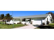 White single story house with a gray roof, driveway, and lawn at 20430 Edgewater Dr, Port Charlotte, FL 33952