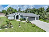 Single-story home with gray roof, landscaping, and a three-car garage at 4767 Maurbach Ter, North Port, FL 34286