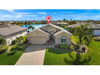 Beautiful home featuring a well-maintained lawn and a brick driveway with a two-car garage at 24723 Rio Villa Lakes Cir, Punta Gorda, FL 33950