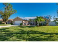 Charming single-story home with a two-car garage, lush lawn, and neatly landscaped front yard at 86 Zenith St, Port Charlotte, FL 33954