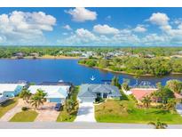 Aerial view of waterfront home with private dock and lush landscaping at 430 Spring Lake Nw Blvd, Port Charlotte, FL 33952