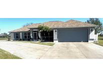 Single-story home with attached garage and landscaped yard at 98 Seasons Dr, Punta Gorda, FL 33983