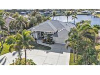 Home's exterior boasts a gray roof and palm trees at 18061 Cullman Ave, Port Charlotte, FL 33948