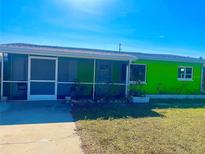 Cozy single-story home with bright green exterior paint, screen door, and well-maintained lawn at 30431 Holly Rd, Punta Gorda, FL 33982