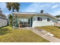 Charming light green house with covered porch and landscaped lawn at 3999 Conway Blvd, Port Charlotte, FL 33952