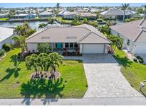 Aerial view of a waterfront home with a large backyard and paved driveway at 2199 El Cerito Ct, Punta Gorda, FL 33950