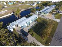 Aerial view of waterfront property with canal access and lush landscaping at 4156 Bardot Rd, Port Charlotte, FL 33953