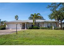 Single-story home with landscaped lawn, driveway, and attached garage at 7529 Coral Tree, Punta Gorda, FL 33955