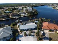 Waterfront home featuring private dock, screened pool, metal roof, lush landscaping and canal access at 193 N Waterway Nw Dr, Port Charlotte, FL 33952