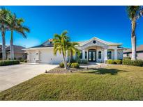 Single-story home with a stone facade, two-car garage, and manicured lawn at 386 Royal Poinciana, Punta Gorda, FL 33955