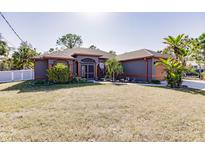 Single-story home with a gray exterior, orange accents, and a well-manicured lawn at 5188 Balmor Ter, North Port, FL 34288
