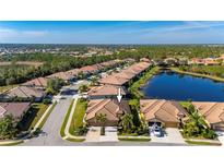 Aerial view of a house in a residential neighborhood near a lake at 2427 Daisy Dr, North Port, FL 34289