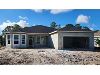 New home features a concrete block exterior, completed roof, and an attached two-car garage at 349 Gold Tree, Punta Gorda, FL 33955