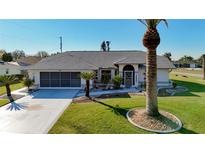 Single-story home with landscaped yard, driveway, and palm tree at 4365 Aladdin Ave, North Port, FL 34287